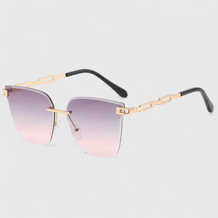 A woman wearing bold square sunglasses with brown gradient lenses and gold-tone chain-link arms.