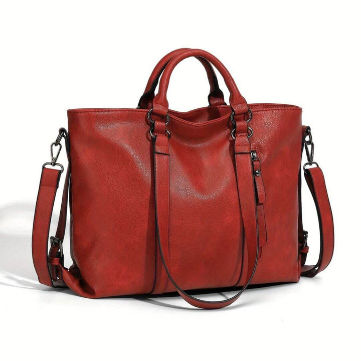 A woman carrying a roomy everyday tote bag on her shoulder while out for coffee in town.