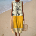 A woman wearing a sleeveless printed summer dress with a soft, flowing silhouette on a sunny day.