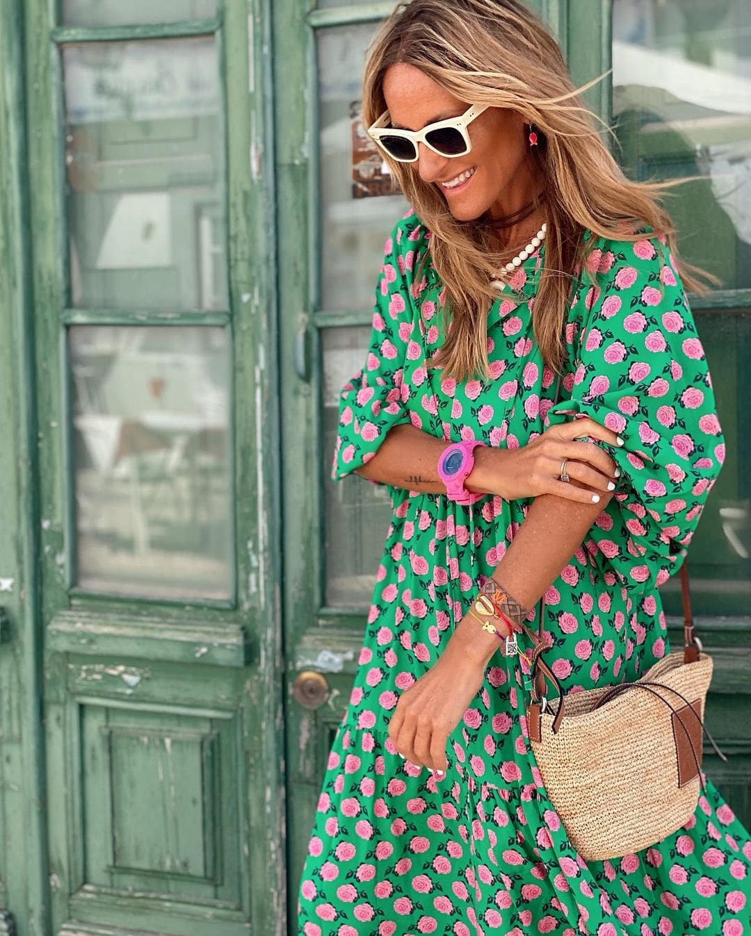 A woman wearing the Erin spring print dress in green and pink tones, styled for a day out.