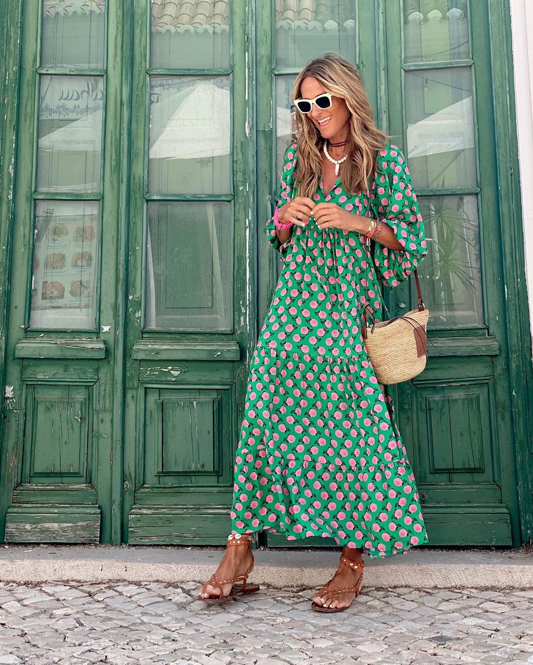 A woman wearing the Erin spring print dress in green and pink tones, styled for a day out.