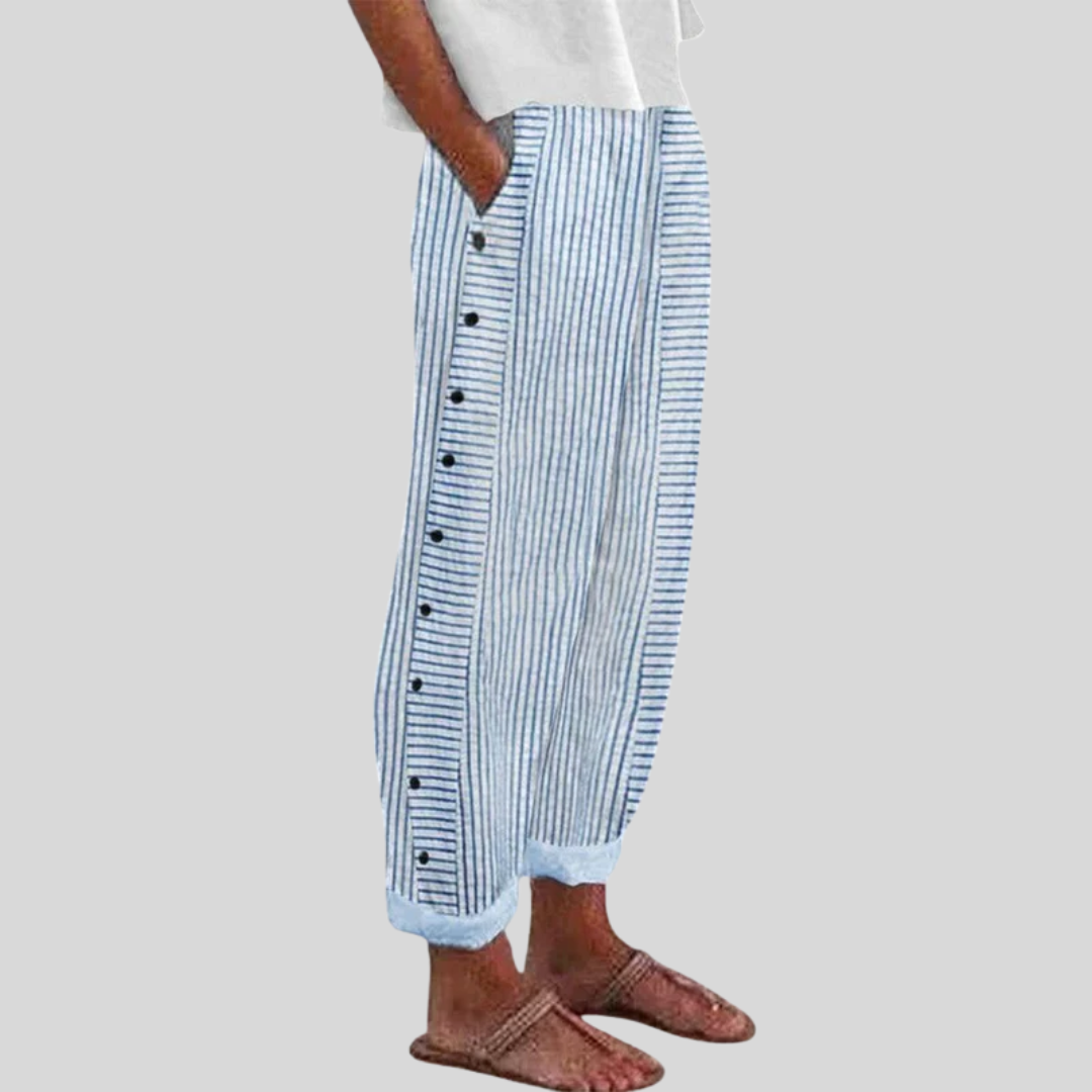 A woman wearing elegant everyday pants in a fine blue stripe with a wide cut and side buttons.