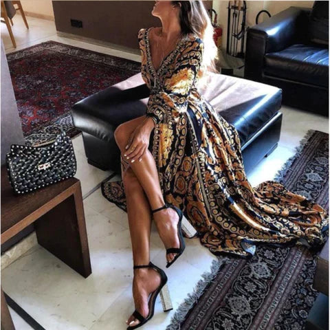 Woman at golden hour wearing the Eileen vintage print maxi dress with a waist belt and long statement sleeves.
