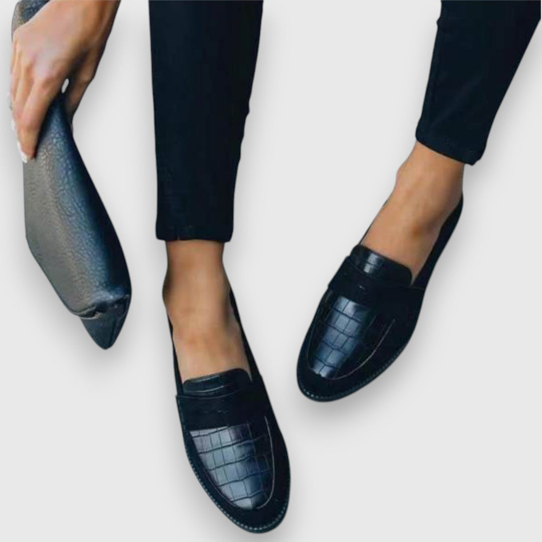 A woman wearing elegant flat loafers with a refined finish