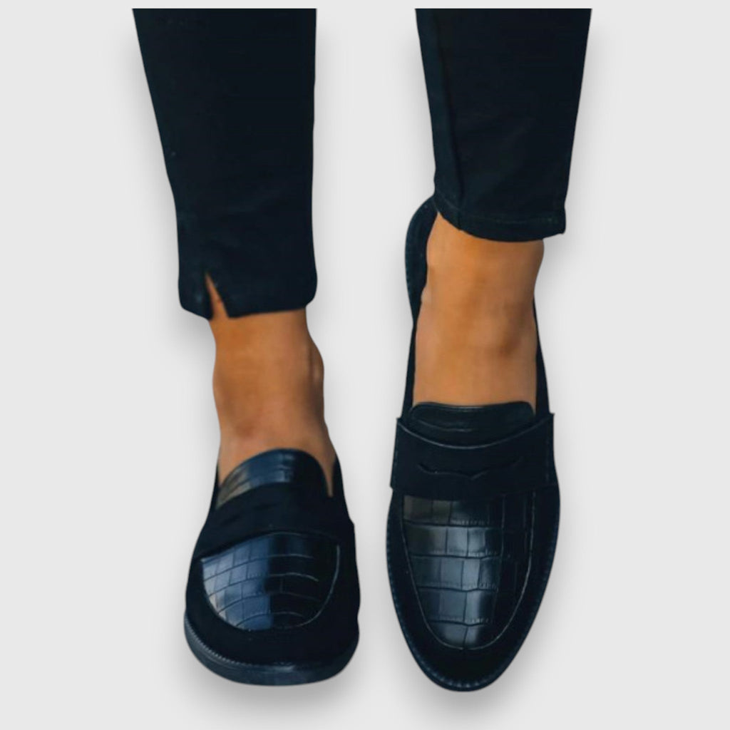 A woman wearing elegant flat loafers with a refined finish