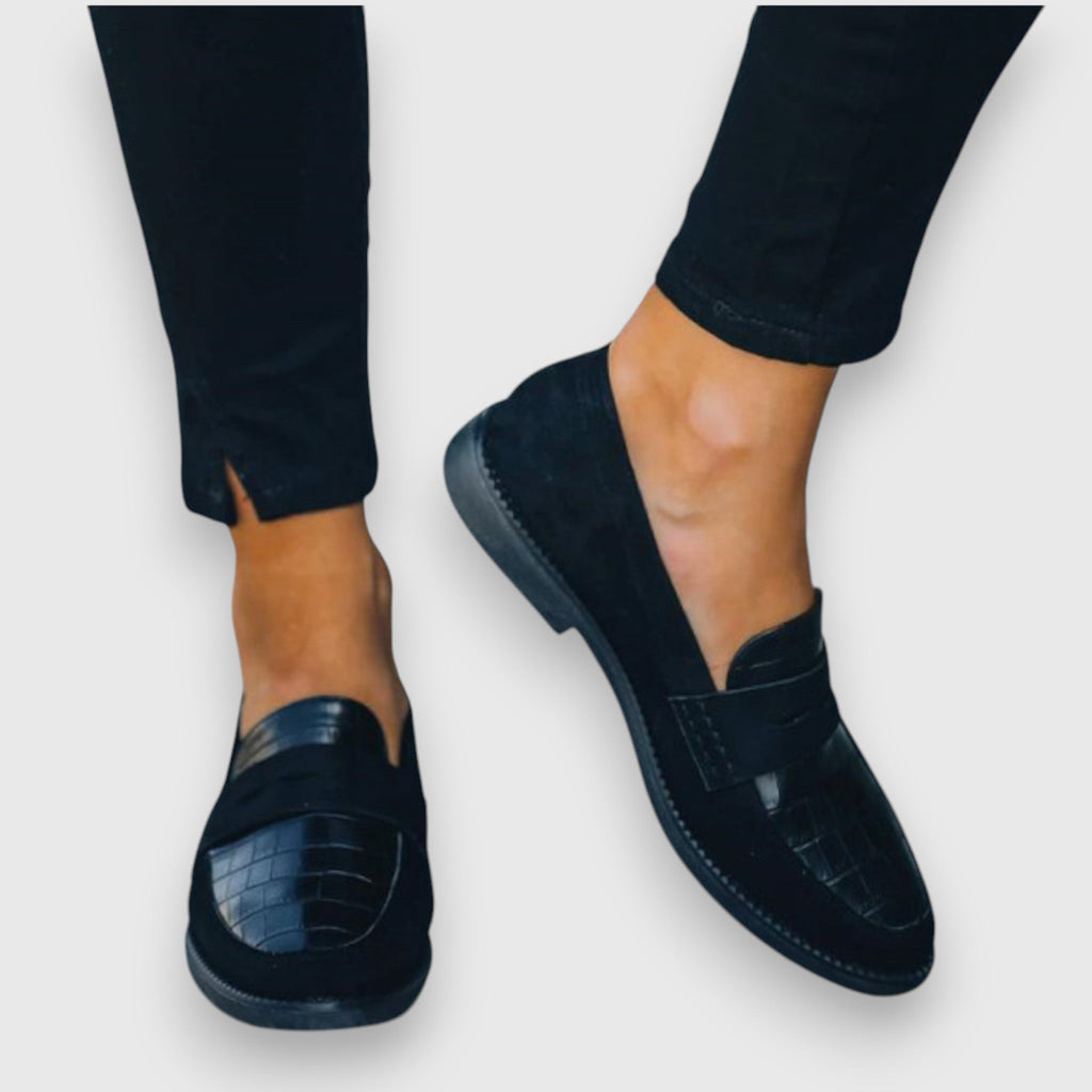 A woman wearing elegant flat loafers with a refined finish