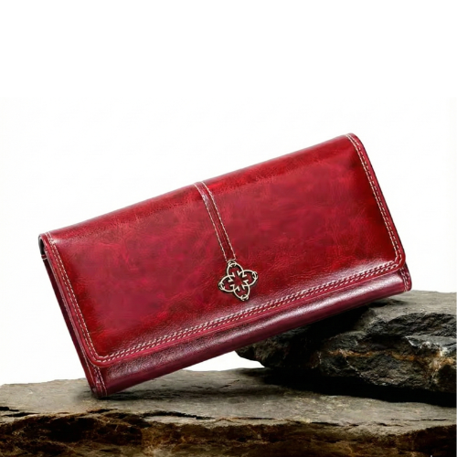 A woman holding a long flap-over wallet, tucking a card into its slot.