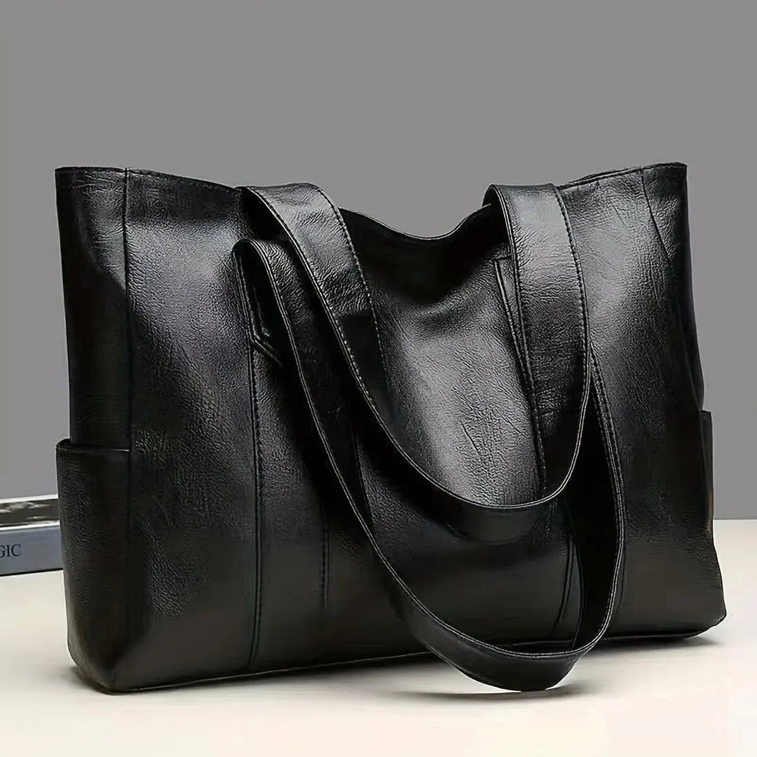A woman carrying a classic elegant bag with a rich finish over her shoulder