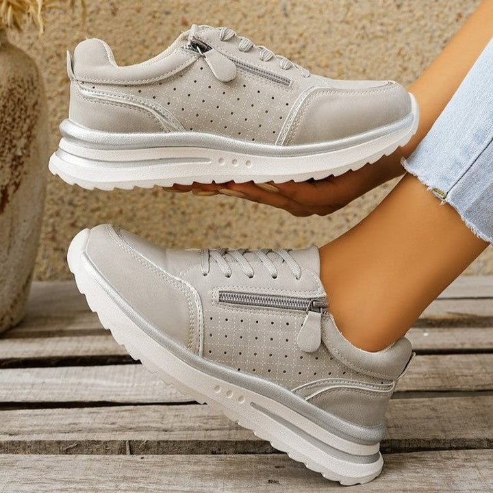 A woman standing comfortably in orthopaedic arch support sneakers.