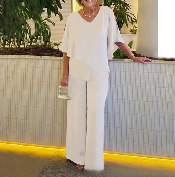 A woman wearing an asymmetric flowing top with matching wide-leg pants.