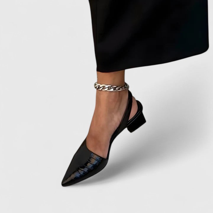 A glossy black croc-effect pointed-toe slingback with a low block heel, shown at an angle.