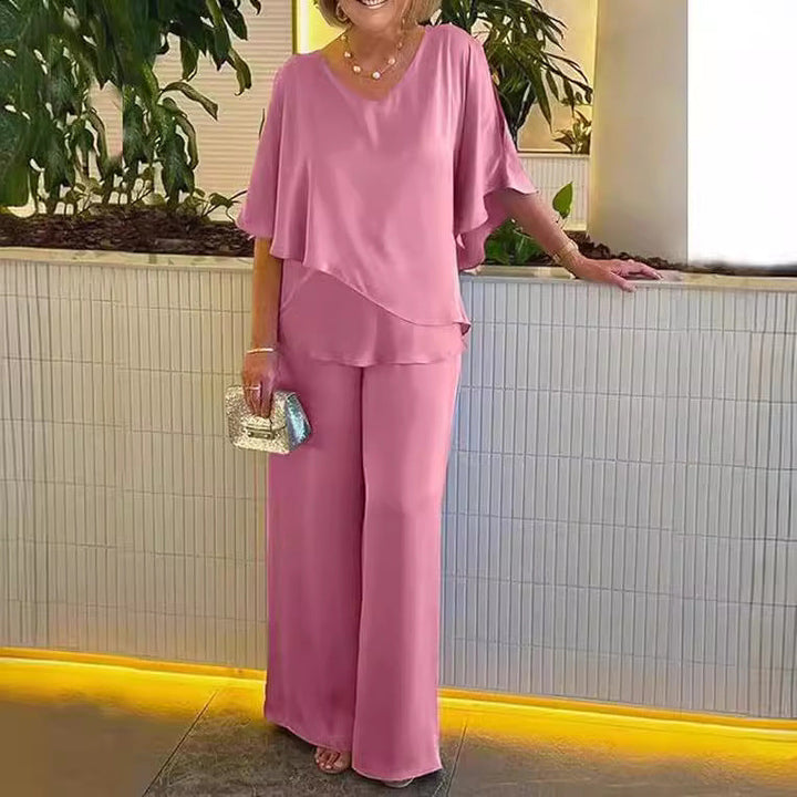 A woman wearing an asymmetric flowing top with matching wide-leg pants.