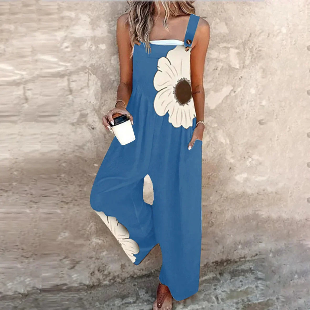 A woman wearing elegant black overalls with a single large cream bloom and adjustable straps.