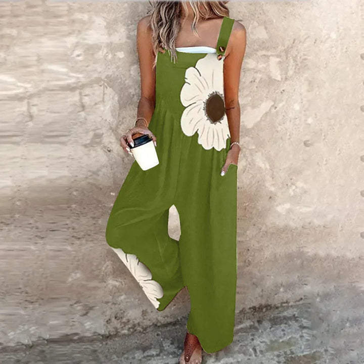 A woman wearing elegant black overalls with a single large cream bloom and adjustable straps.
