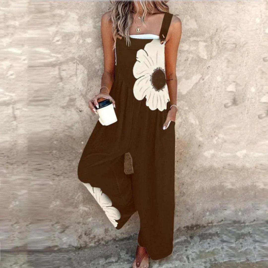 A woman wearing elegant black overalls with a single large cream bloom and adjustable straps.