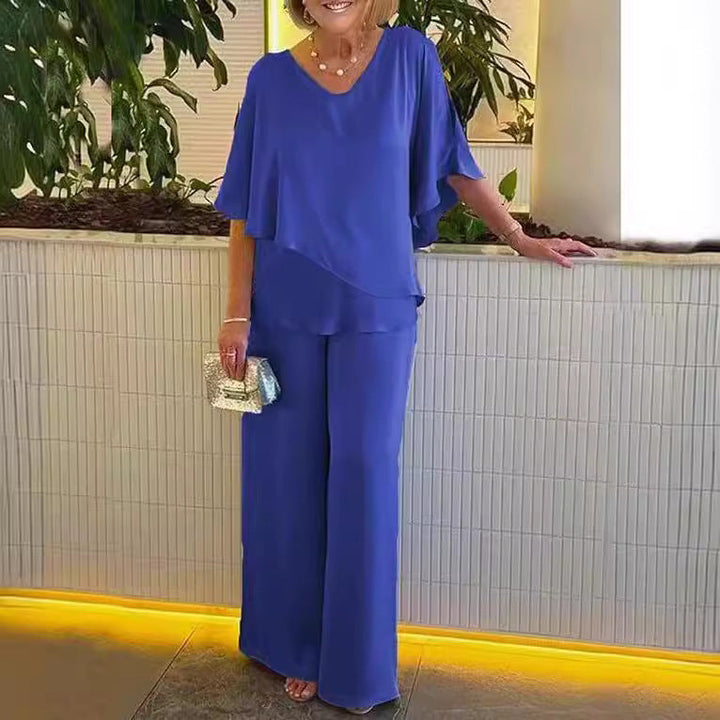 A woman wearing an asymmetric flowing top with matching wide-leg pants.
