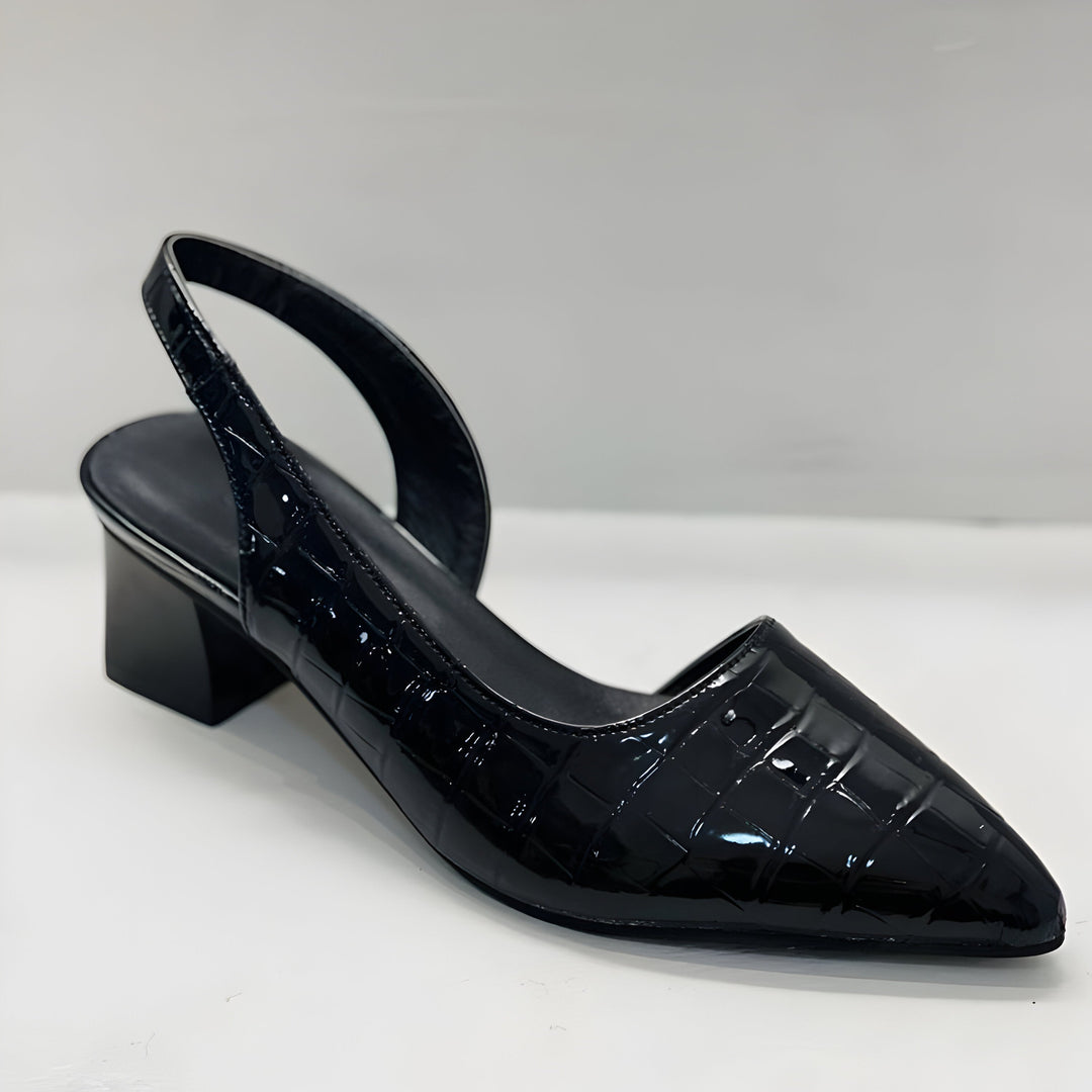 A woman wearing black comfort block heels with a roomy toe box and cushioned sole.