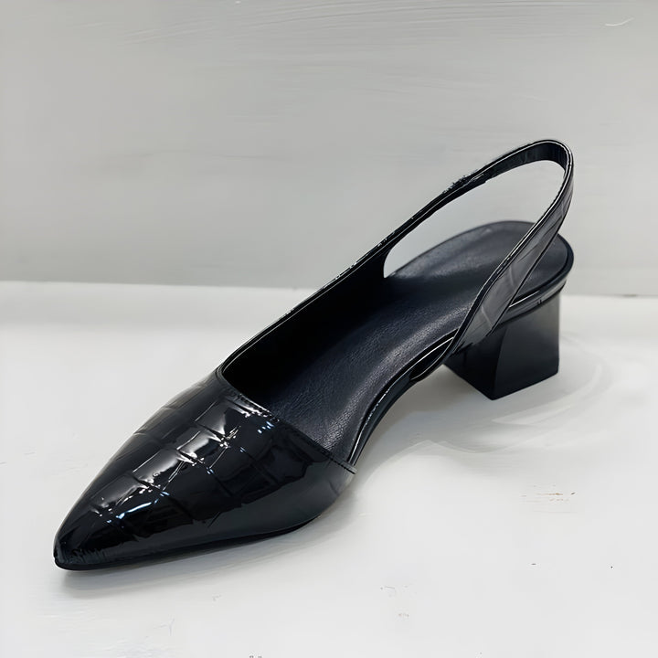 A woman wearing black comfort block heels with a roomy toe box and cushioned sole.