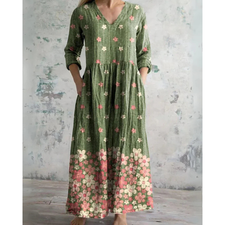 A woman wearing the Brenda vintage floral maxi dress with a gathered waist and flowing skirt at an outdoor celebration.