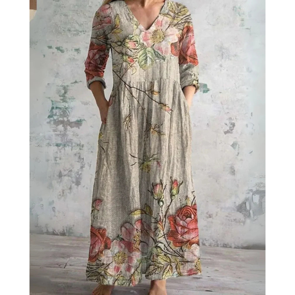 A woman wearing the Brenda vintage floral maxi dress with a gathered waist and flowing skirt at an outdoor celebration.