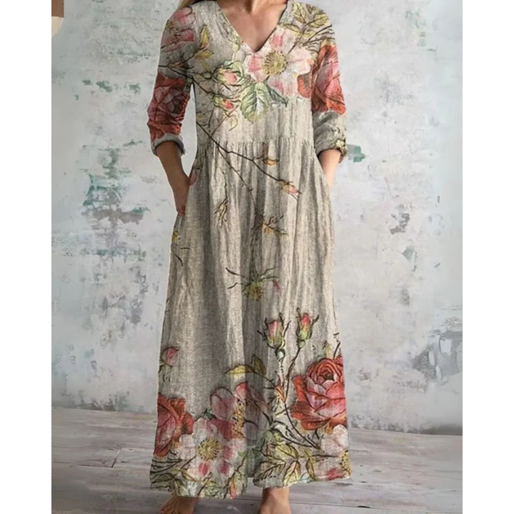 A woman wearing the Brenda vintage floral maxi dress with a gathered waist and flowing skirt at an outdoor celebration.