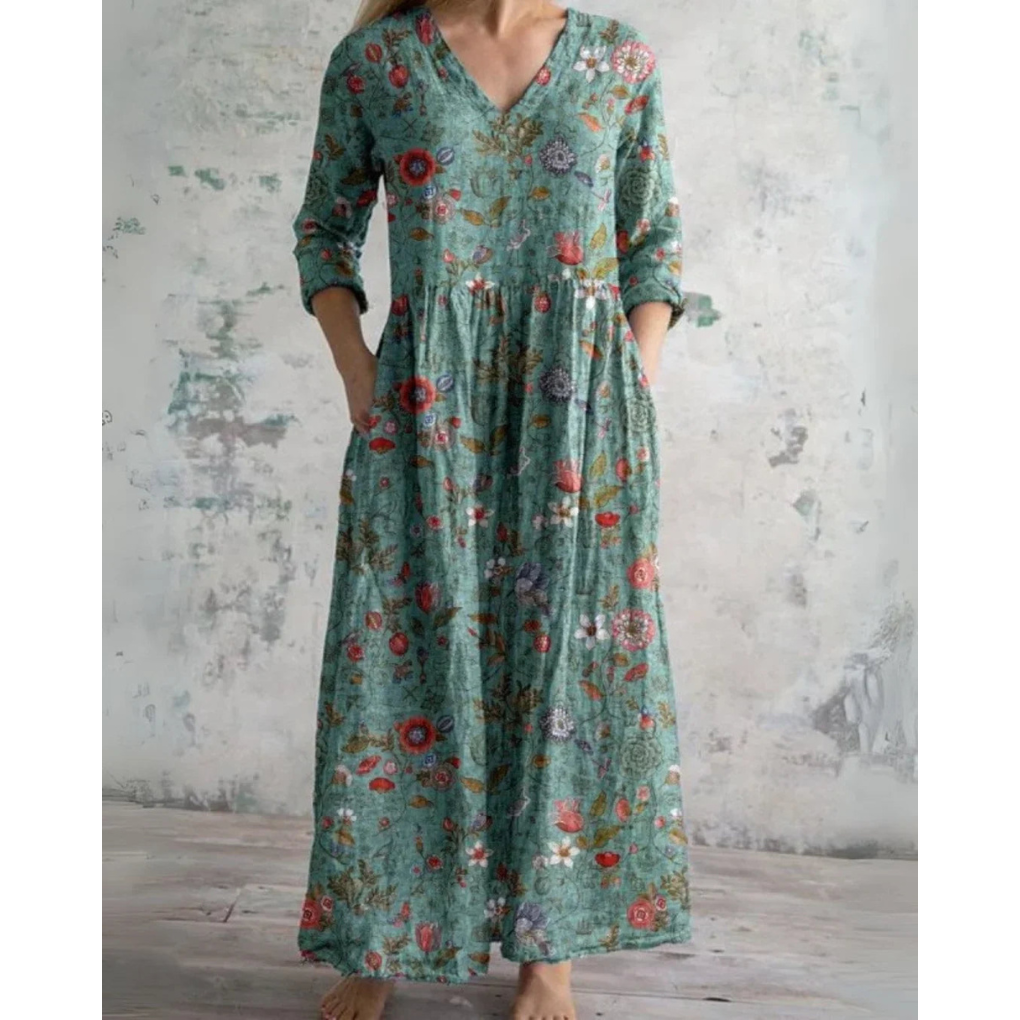A woman wearing the Brenda vintage floral maxi dress with a gathered waist and flowing skirt at an outdoor celebration.