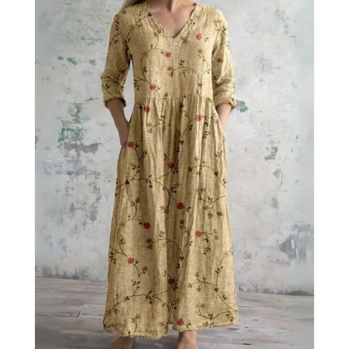 A woman wearing the Brenda vintage floral maxi dress with a gathered waist and flowing skirt at an outdoor celebration.