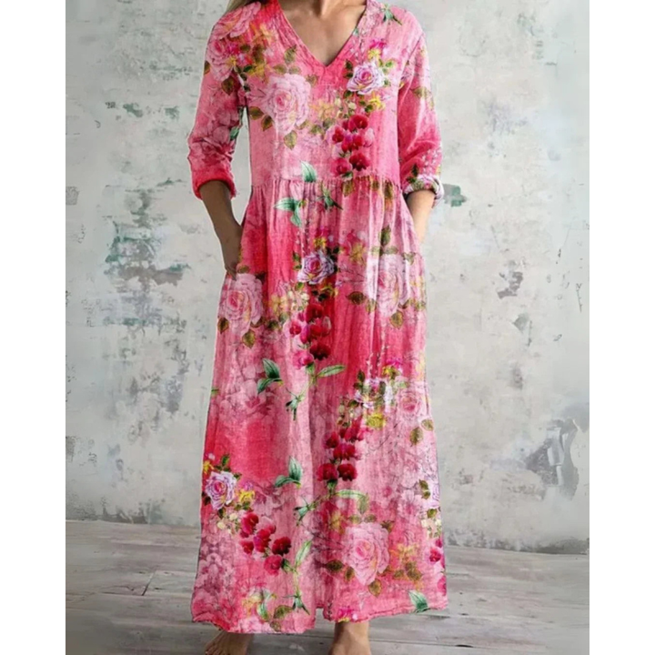 A woman wearing the Brenda vintage floral maxi dress with a gathered waist and flowing skirt at an outdoor celebration.
