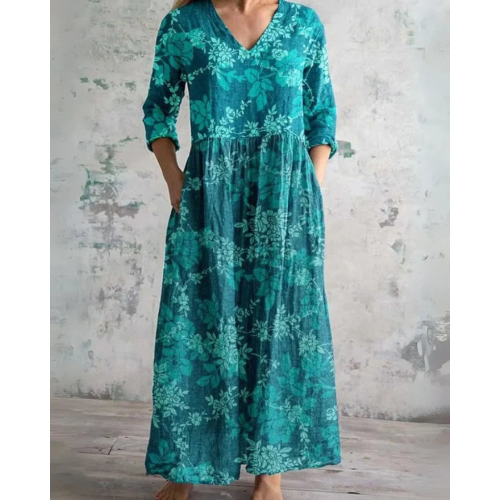 A woman wearing the Brenda vintage floral maxi dress with a gathered waist and flowing skirt at an outdoor celebration.