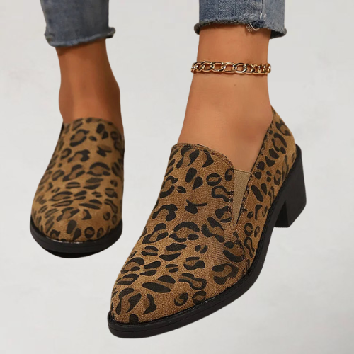 A woman wearing leopard-print loafers with jeans, stepping out with easy confidence.