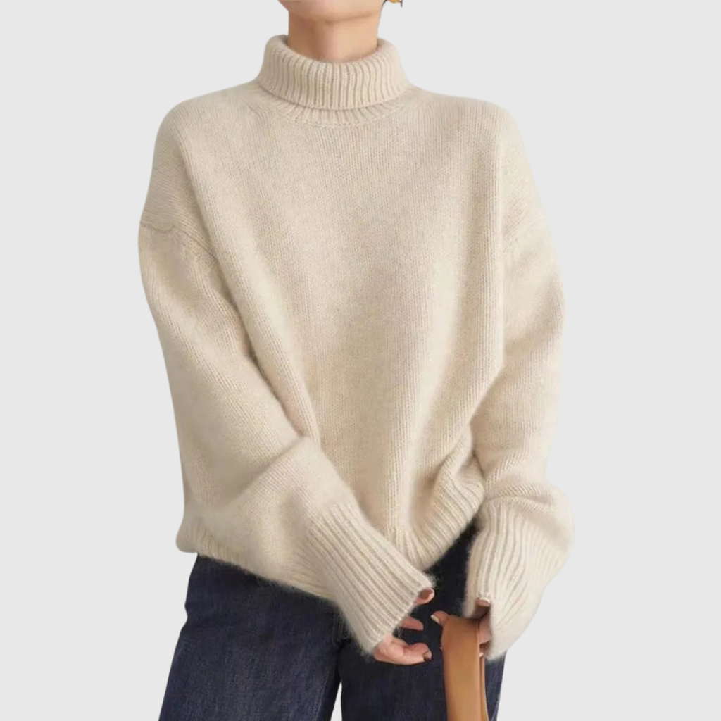 A woman wearing a beige roll-neck sweater, relaxed and warm, paired with pants.