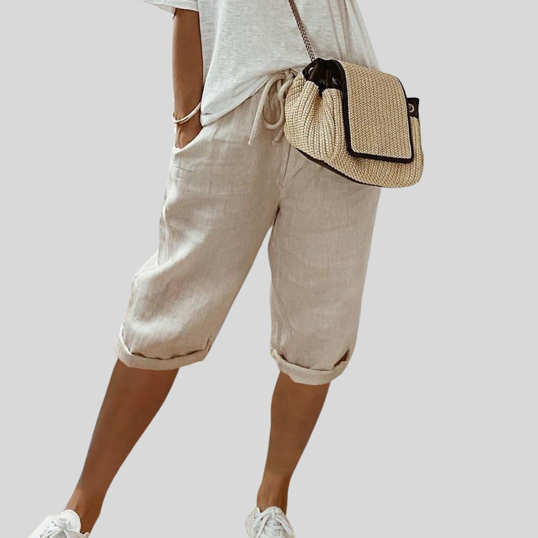 A woman wearing elegant flowing shorts with a soft elastic waist and deep pockets.