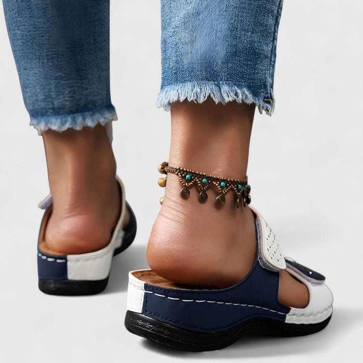 A woman walking confidently in wide-fit comfort sandals with a cushioned, supportive footbed.