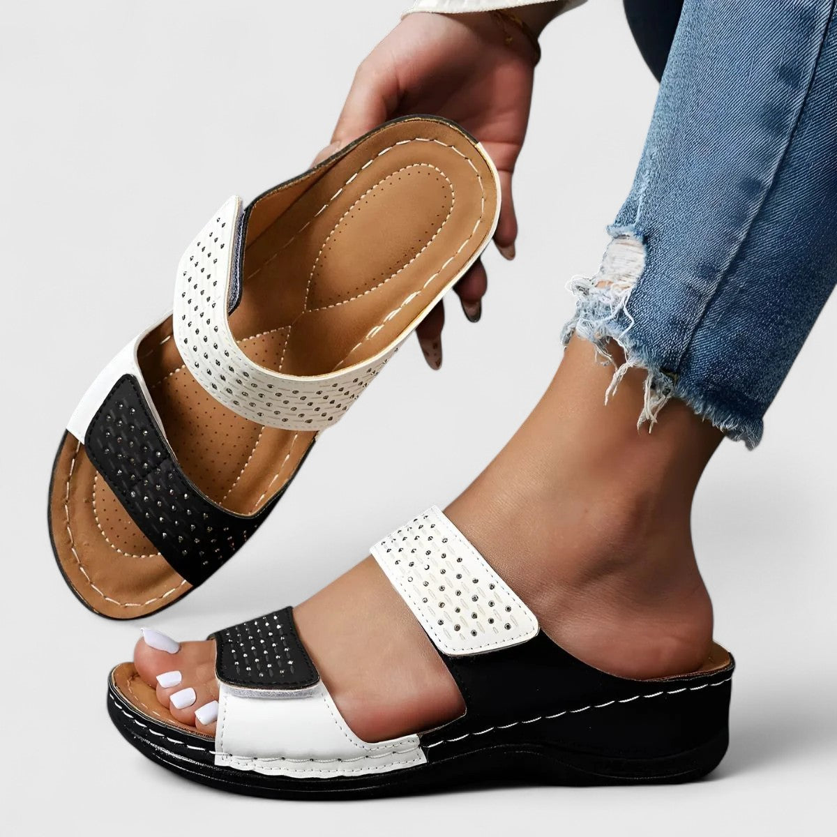 A woman walking confidently in wide-fit comfort sandals with a cushioned, supportive footbed.