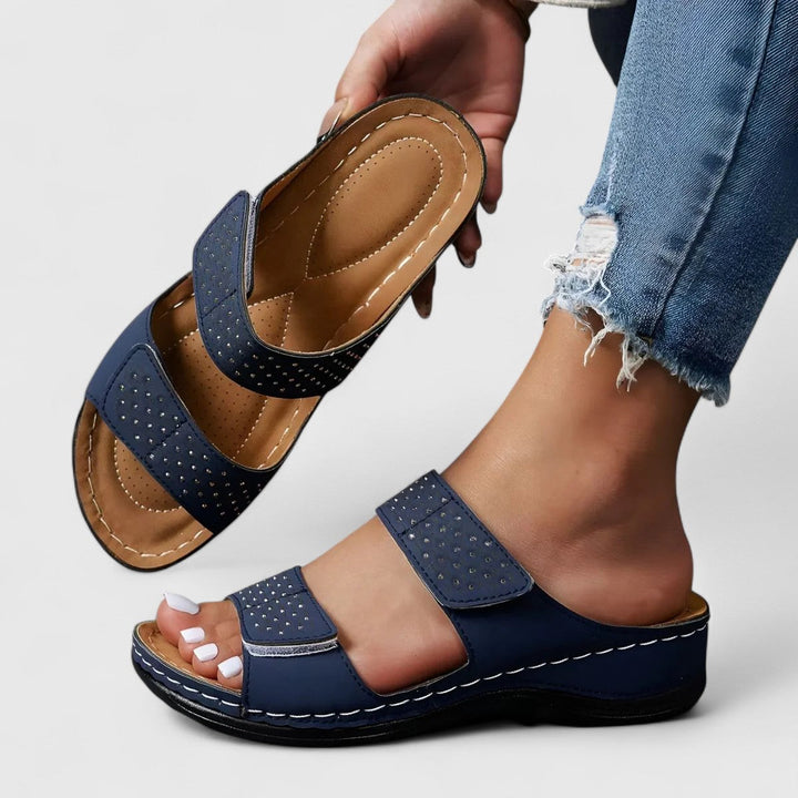 A woman walking confidently in wide-fit comfort sandals with a cushioned, supportive footbed.