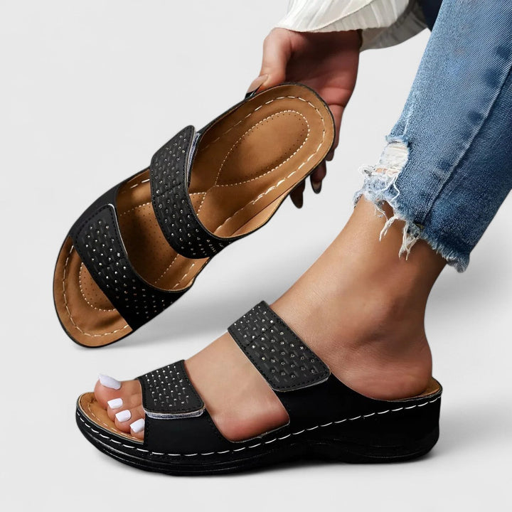 A woman walking confidently in wide-fit comfort sandals with a cushioned, supportive footbed.