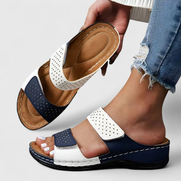 A woman walking confidently in wide-fit comfort sandals with a cushioned, supportive footbed.