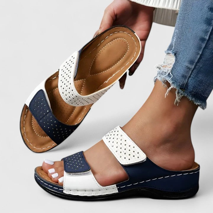 A woman walking comfortably in open-toe wide-fit orthopaedic sandals with a cushioned footbed.
