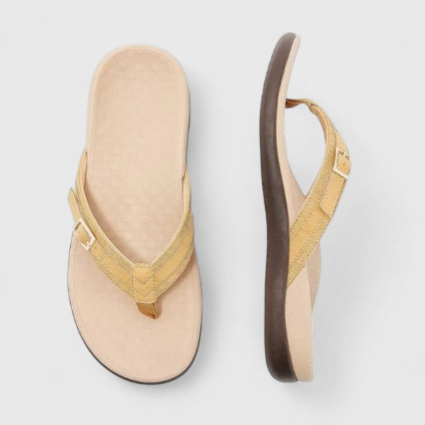 A woman in light blue lightweight flip-flops relaxing on a sunny terrace, feet light and comfortable.