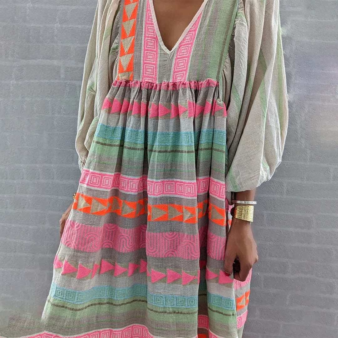 Woman wearing the Holly™ colourful geometric print boho dress with puffed sleeves, out enjoying a casual day.