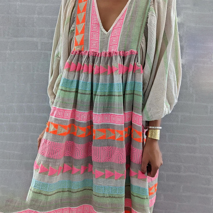 Woman wearing the Holly™ colourful geometric print boho dress with puffed sleeves, out enjoying a casual day.