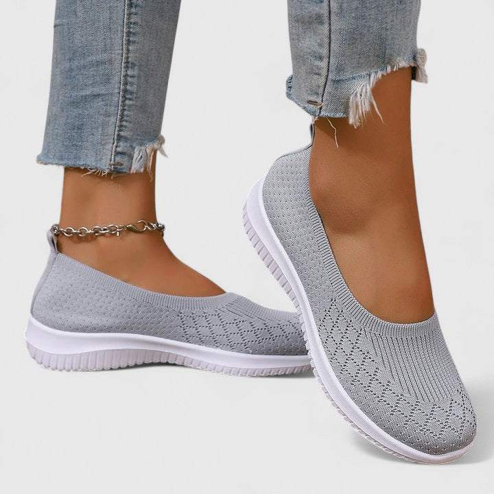 A woman slipping into soft cushioned orthopaedic slip-on shoes