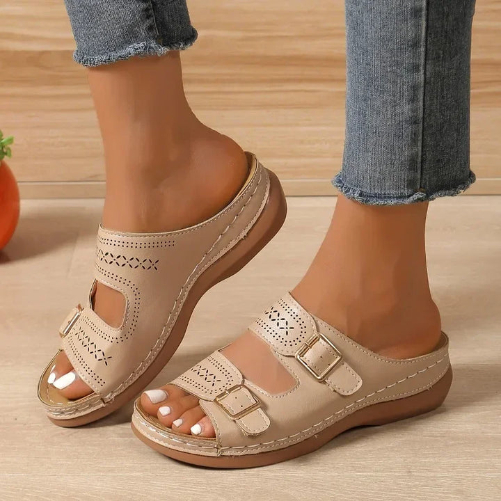 A woman walking with ease in wide-fit adjustable orthopaedic sandals with cushioned soles.