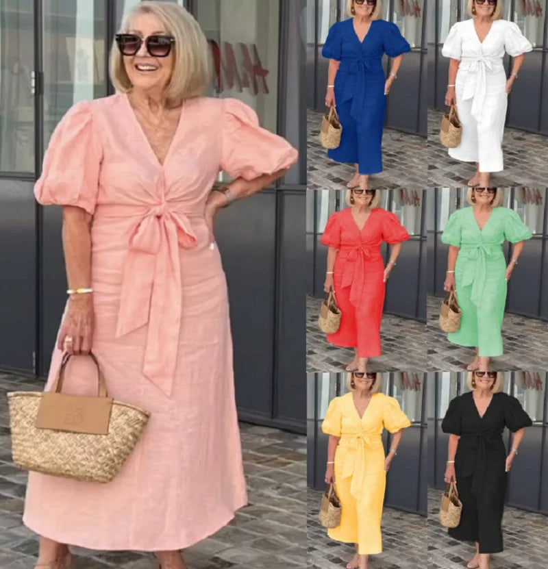 Woman wearing the Christina bow-front midi dress with puff sleeves at a garden party.