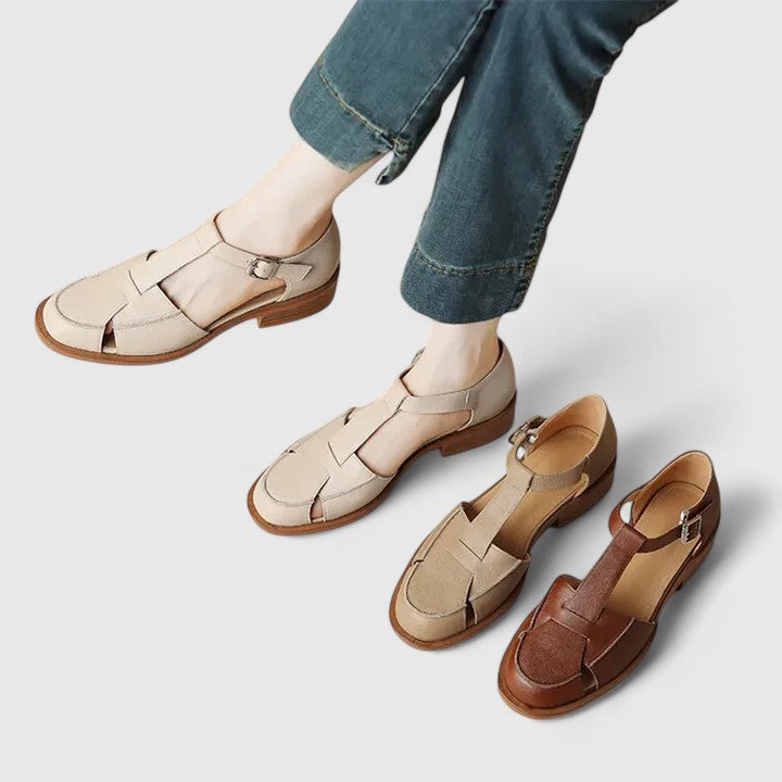 A woman wearing brown Mary Jane sandals with a T-strap and buckle, paired with a summer dress.