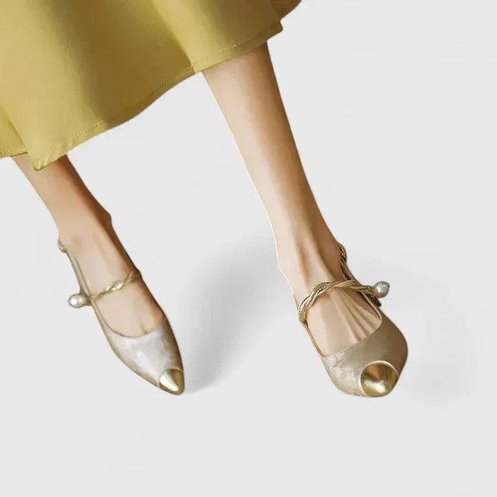 A woman standing elegantly in low cushioned kitten heels with a wide, supportive fit.