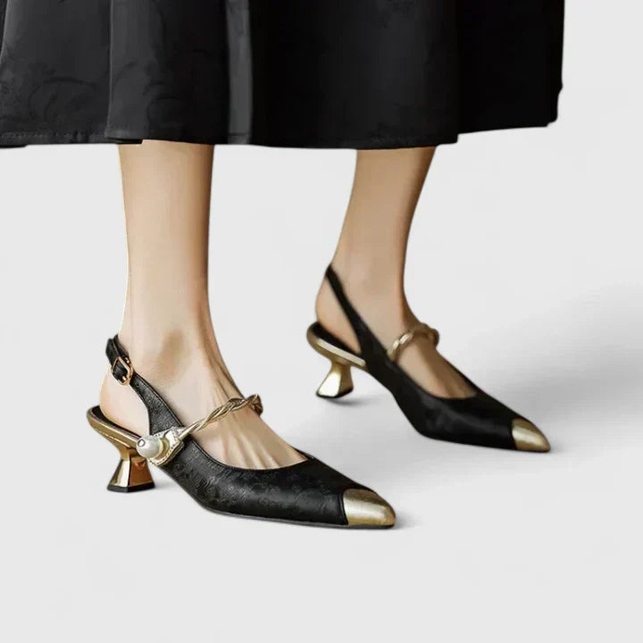 A woman standing elegantly in low cushioned kitten heels with a wide, supportive fit.
