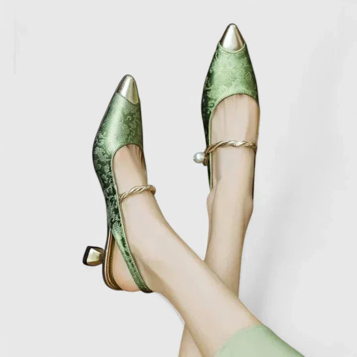 A woman standing elegantly in low cushioned kitten heels with a wide, supportive fit.