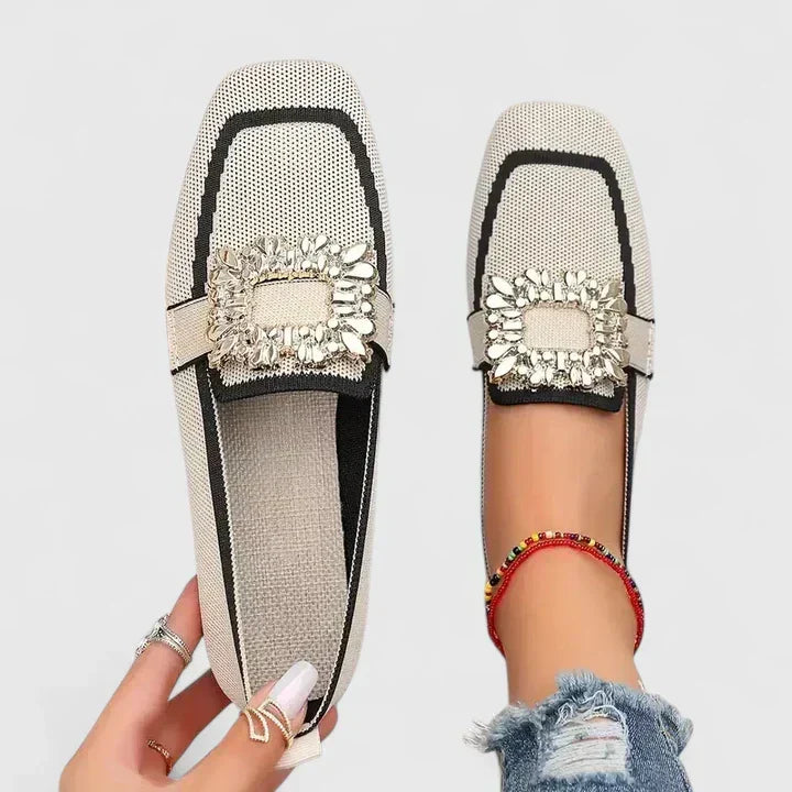 A woman wearing embellished comfort flats with a sparkling jewelled square buckle