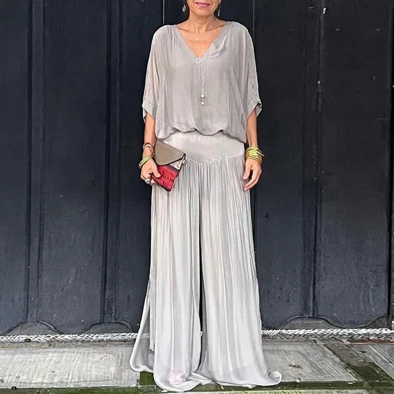 A woman wearing a flowing lounge two-piece set with a V-neck top and wide-leg pants.